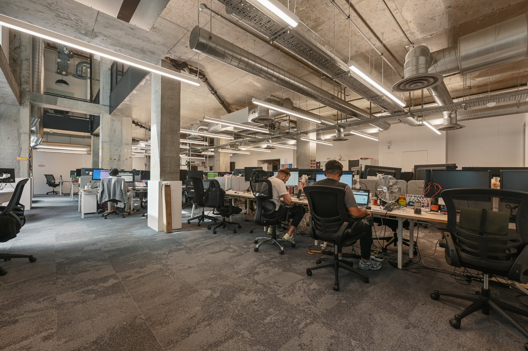 Occupied open-plan office with exposed concrete and services